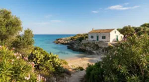 Casa in pietra affacciata su una piccola baia sabbiosa con mare cristallino in Puglia
